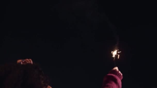 Çok kültürlü bir kadın çatıdaki bir partide maytapla dans ediyor, geceleri kutlama yapıyor. Yüksek kalite 4K görüntü — Stok video
