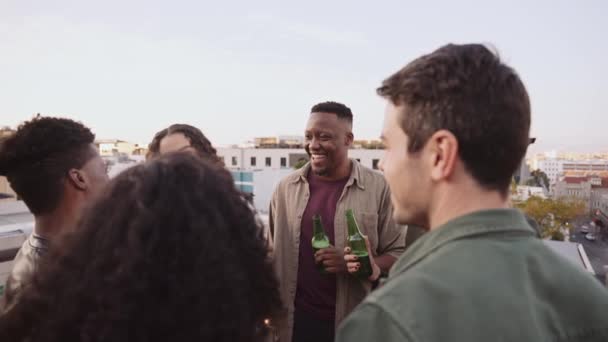 Çok ırklı bir arkadaş grubu akşamları bir partide çatıda içkilerle sosyalleşiyorlar. Yüksek kalite 4k görüntü — Stok video