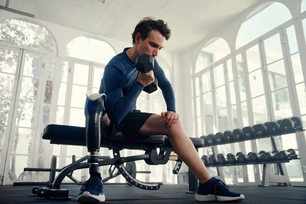 Atleta con diferentes capacidades haciendo rizos de bíceps en el gimnasio preparándose para los Juegos Paralímpicos —  Fotos de Stock
