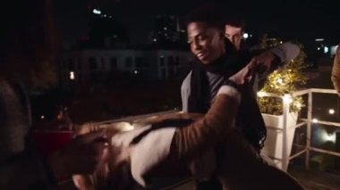 Siyah erkek ve beyaz kadın gecenin bir yarısı şehirdeki bir çatı partisinde dans ediyorlar.