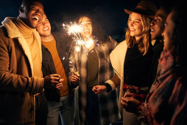 一群年轻的成人多元文化朋友在一个有火花的屋顶派对上大笑 — 图库照片