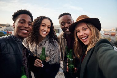 Çok kültürlü genç yetişkinlerin portresi şehrin terasında birlikte sosyalleşiyorlar.. 