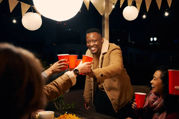 Czarny mężczyzna stojący, wiwatuje z grupą różnorodnych przyjaciół świętujących na imprezie na świeżym powietrzu — Zdjęcie stockowe