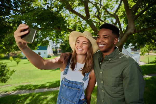 Granjeros de raza mixta machos y hembras parados al aire libre tomando selfie — Foto de Stock