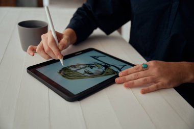Beyaz kadın tasarımcı, dijital tablette sanat yaratıyor.