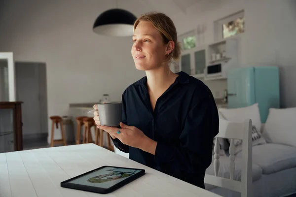 Blanke vrouwelijke mode-ontwerper het drinken van koffie tijdens het werken vanuit huis — Stockfoto