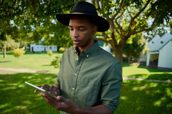 야외에서 디지털 태블릿으로 타자를 치고 있는 혼합 인종 남자 농부 — 스톡 사진