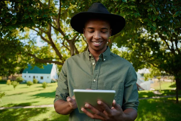 Mestiça agricultor masculino em pé ao ar livre digitando em tablet digital — Fotografia de Stock