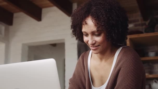 Motiverad biracial mamma arbetar på laptop hemma i sitt moderna kök. — Stockvideo