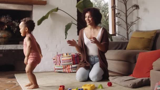 Biracial young child and mom dancing and laughing in modern-styled living room in the daytime — Stock Video