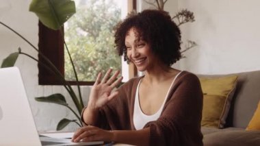 Gündüz vakti modern stil oturma odasında çalışırken yerde oturan melez genç bir kadın..