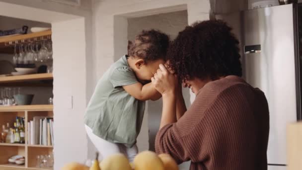 Biracial mother and daughter laughing and playing games in modern-styled kitchen. Happiness and love. — Stock Video