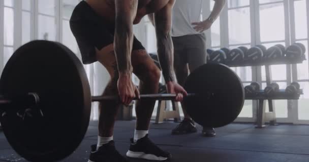 Vit man tränar, lyfta vikter med tränare i modern stil gym — Stockvideo