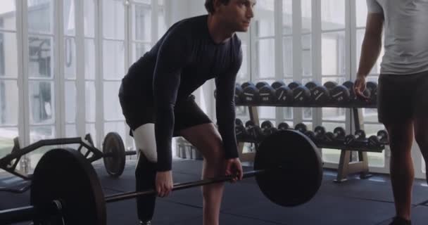 Běloch samec s protézou zvedací závaží nohou, trenér v moderní tělocvičně — Stock video