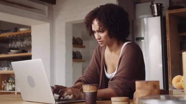 Stressad och övertrött biracial mamma arbetar på laptop hemifrån i modernt kök. — Stockvideo