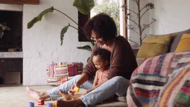 Biracial perempuan dan anak kecil bermain dengan mainan di ruang tamu modern di siang hari — Stok Video