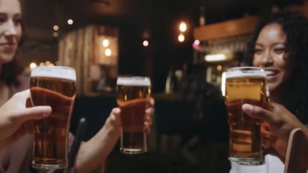 Multi-ethnische Gruppe von Freunden klimpert in einem Restaurant mit Biergläsern. — Stockvideo