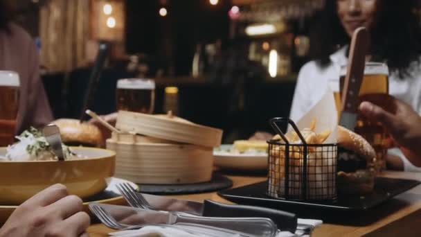 Multietnisk grupp vänner klinkande glas öl på en restaurang. — Stockvideo
