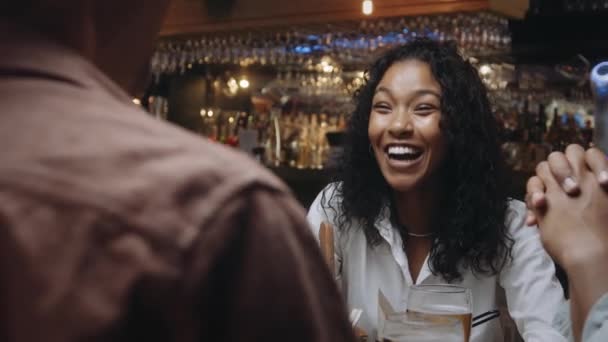 Mnohostranná žena a muž v restauraci se skupinou přátel, kteří se smějí a mluví. — Stock video