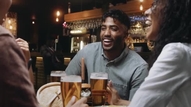 Eine multiethnische Gruppe von Freunden beim Abendessen und Bier in einem Restaurant und bei angenehmen Gesprächen — Stockvideo