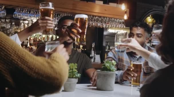 Multi-ethnische Freundesgruppe klirrt bei Festessen im Restaurant mit Gläsern. — Stockvideo