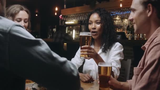 多民族の友人のレストランでビールのグラスをクリックして. — ストック動画