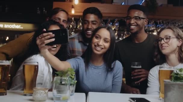 Groupe multi-ethnique d'amis prenant un selfie dans un restaurant. — Video