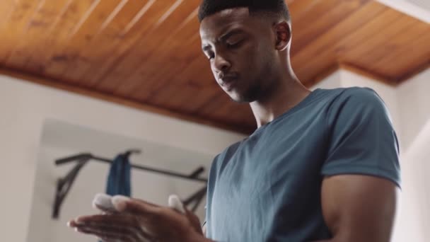 Genç Siyahi Erkek Spor Salonunda Ağırlık Kaldırmak Için Ellerine Pudra — Stok video