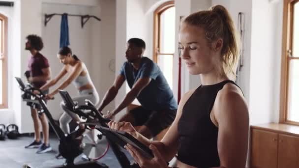 在室内健身馆使用电子平板电脑的已知年轻白人女性 — 图库视频影像
