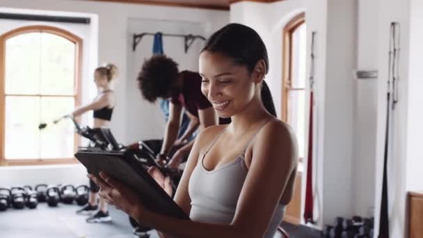 快乐而自豪的年轻成年女性健身馆老板运用科技经营室内健身馆 — 图库视频影像