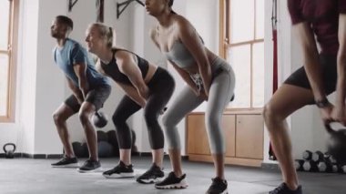 Sağlıklı, yetişkin arkadaşlardan oluşan çok kültürlü bir grup kapalı spor salonundaki grup fitness sınıfında egzersiz yapıyor.. 