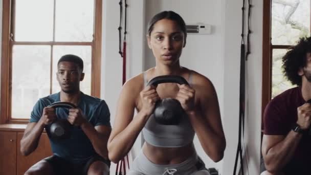 Spor Salonunda Kettlebell Ile Grup Fitness Dersinde Çömelmiş Genç Yetişkinlerden — Stok video
