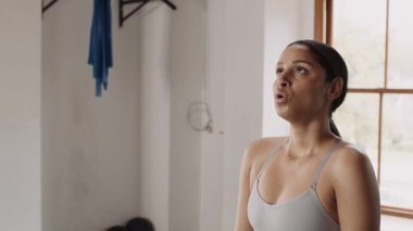 Kendine güveni tam, genç bir kadın. Spor salonundaki egzersizler arasında nefes alıyor.. 