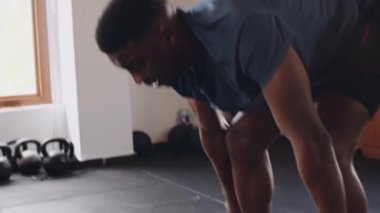 Siyah, genç bir erkek spor salonunda topa vuruyor. Çok çalışıyor ve kararlı.. 