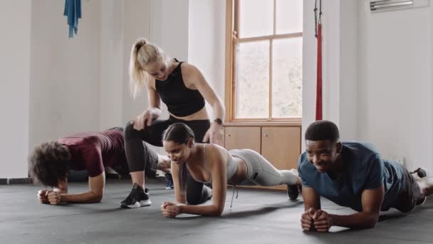 Caucasian Trainer Correcting Clients Form Diverse Group Individuals Planking Group — Video Stock