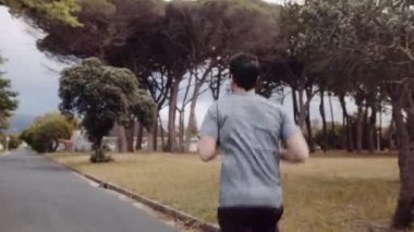 Beyaz erkek, bir yerleşim bölgesinde caddede koşuya çıkıyor. Yüksek kalite 4k görüntü