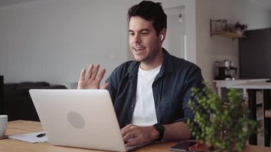Evde çalışan beyaz bir adam laptopuyla video görüşmesi yapıyor. Yüksek kalite 4k görüntü