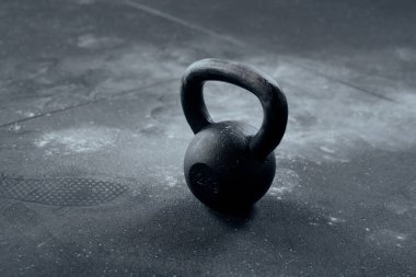 Close-up of kettlebell surrounded by chalk at the gym