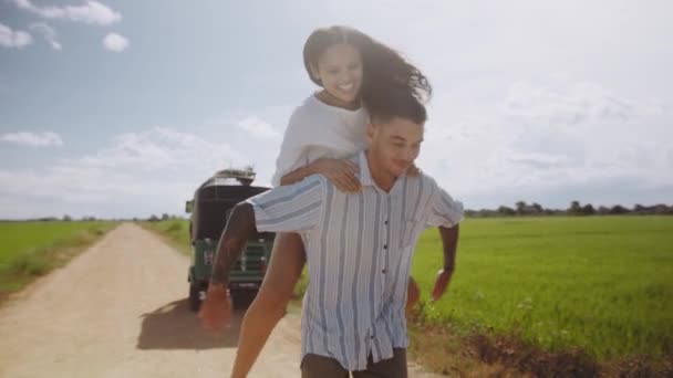 Young Biracial Woman Getting Piggyback Boyfriend While Walking Dirt Road — Stockvideo