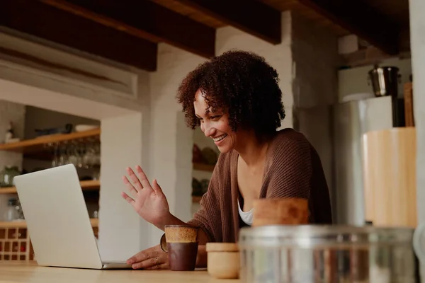 Young Biracial Woman Casual Clothing Gesturing While Working Laptop Kitchen — ストック写真