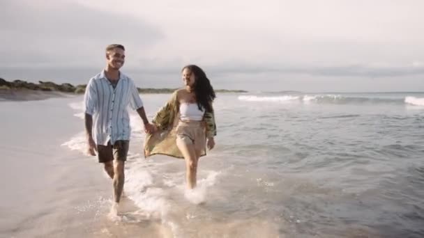 Affectionate Young Couple Holding Hands While Dancing Splashing Sea — Stock Video