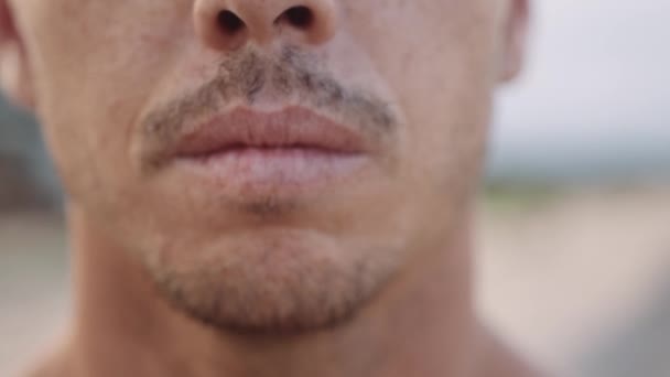 年轻的白人男子在海滩吸入和呼气的特写镜头 — 图库视频影像