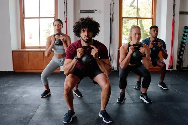 Groep Vastberaden Multiraciale Jonge Volwassenen Doet Kettlebell Squats Sportschool — Stockfoto