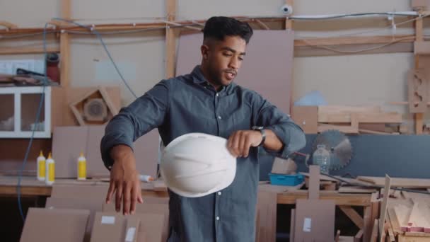 Wielorasowy Młody Człowiek Zdejmujący Kask Bezpieczeństwa Podczas Pracy Fabryce Obróbki — Wideo stockowe