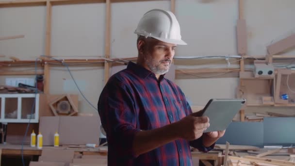 Pria Paruh Baya Multirasial Dengan Helm Pengaman Bergulir Pada Tablet — Stok Video