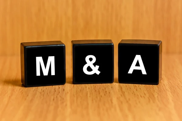 M&A or Merger and Acquisition text on block — Stock Photo, Image