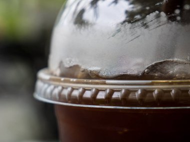 Plastik bardaktaki buzlu kahveyi yakından çek.