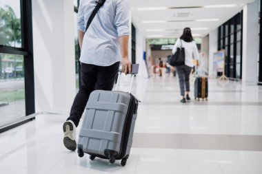 Havaalanında bavul taşıyan Asyalı işadamı..