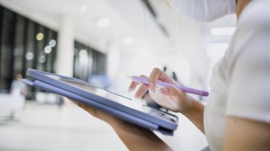 Havaalanında tablet kullanan bir kadının elinin yakın çekimi..