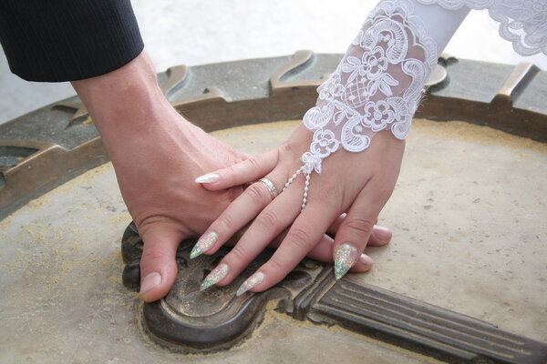 Руки жениха и невесты на каменном ключе
